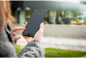 Woman booking free in-home water filter consultation on phone | Safer Water