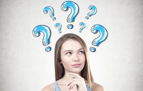 Curious woman surrounded by blue question marks, symbolizing common water filtration questions | Safer Water FAQ