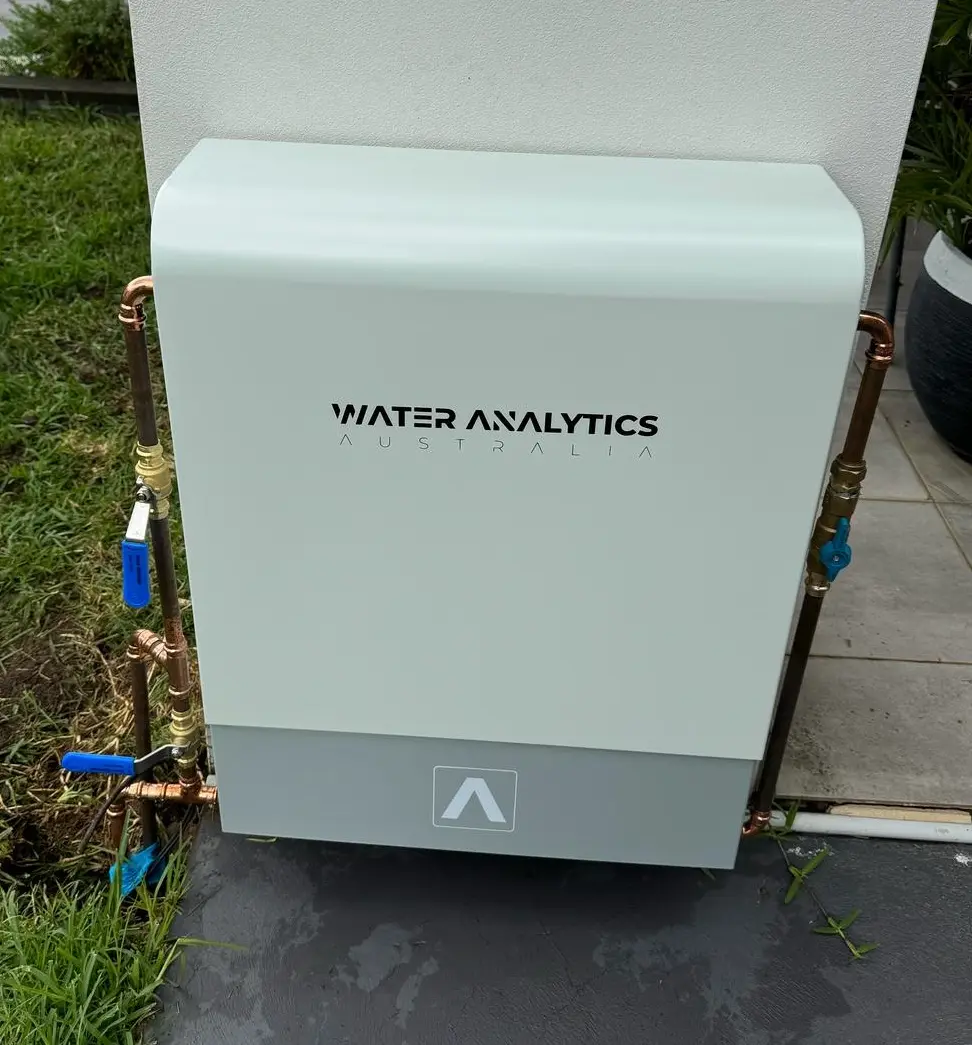 White Water Analytics outdoor water filter housing installed on rendered wall