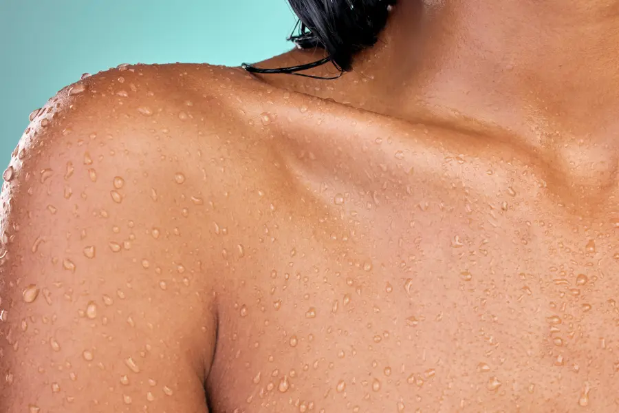 Close-up of woman’s shoulder with water droplets, illustrating skin exposure to chlorinated water